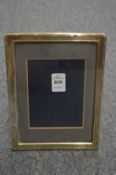 A silver photograph frame with reeded border.