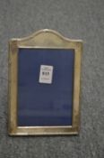 A silver photograph frame with reeded arched shaped frame.