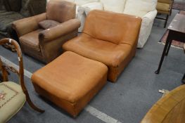 A stylish tan leather upholstered easy chair with matching foot stool.