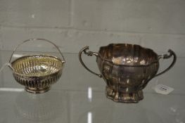 A silver twin handled sugar bowl and a swing handle basket.