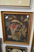 A silk thread and felt picture of a bird with basket of fruit in decorative gilt frame.