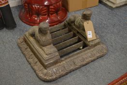 A cast iron boot scraper with sphinx mounts, one corner broken.