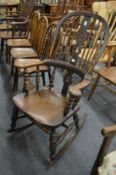 A Victorian beech and elm broad arm rocking chair.