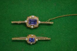 A yellow metal bar brooch set with a blue stone, possibly sapphire, with diamonds, pearls and enamel