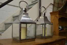 A pair of metal candle lanterns.