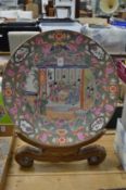 A large Chinese porcelain plate with wooden stand.