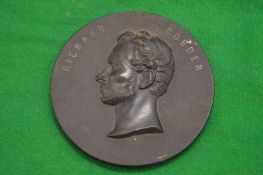 A circular plaque depicting the head and shoulders of Richard Cobden.