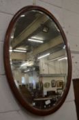 A mahogany framed oval mirror.