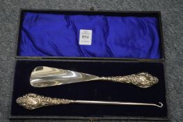 A cased pair of silver handled shoe horn and button hooks.