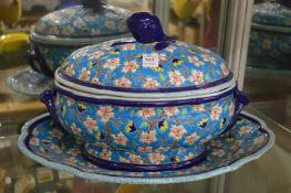 A colourfully decorated French pottery tureen cover and stand.