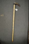 A segmented bone walking stick with horn handle.
