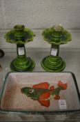 A fish decorated pottery dish and pair of green glazed candlesticks.