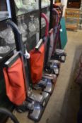 Four Kirby vacuum cleaners with numerous accessories.
