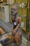An unusual tribal carved wood seated male figure.