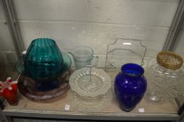 A shelf of colourful and other glassware.