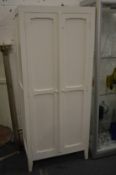 A white painted two door cupboard.