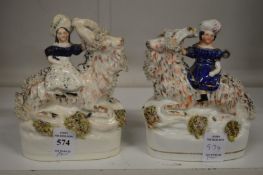 A pair of Staffordshire figures of girls on goats.