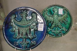 A pair of circular impressed pottery plaques of eagles with turquoise glazed decoration.