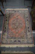 A pink ground Indian rug, the border decorated with elephants 140cm x 100cm.