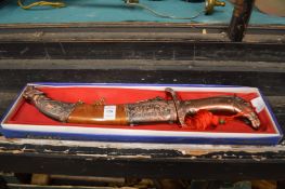 A boxed decorative dagger.