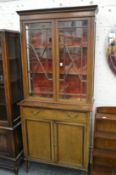 An Edwardian inlaid mahogany cupboard bookcase.