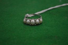 A ladies ring set with a row of five pearls interspersed with small diamonds in original Wilson &