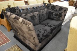 A Knoll large two seater sofa upholstered in a black ground flock decorated fabric.