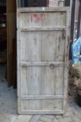 A rustic old pine door with wrought iron fittings.