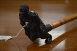 An unusual walking stick, the handle modelled as a man beating a drum.