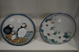 A Highland stoneware plaque painted with puffins together with a similar plate and two Sarah Akin-