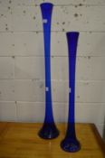 Two tall blue glass vases.