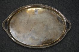 A silver oval twin handled tray with presentation inscription.