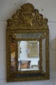A decorative Continental embossed brass framed overmantle or hall mirror.