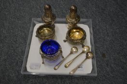 A pair embossed silver pepperettes, a pair of embossed silver circular salts, a cast and pierced