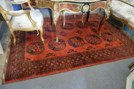 A large Bokhara style carpet, red ground with stylised decoration 233cm x 177cm.