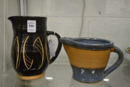 A Milland Pottery jug, black glazed with stylised decoration together with another jug.