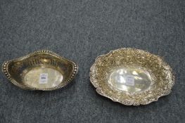 A silver pierced oval basket and a silver embossed oval dish.