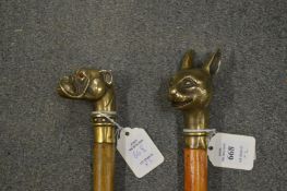 Two walking sticks, the brass handles modelled as a dog and a cat.