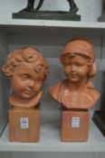 A pair of terracotta busts of children.