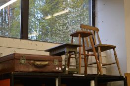 An old leather suitcase, two stools and a chair.