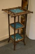 A bamboo stand with three tiers comprising three Minton turquoise glazed hunting tiles.
