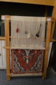 A Persian carpet demonstration loom with part made rug.