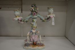 A Dresden porcelain figural two branch candelabra.