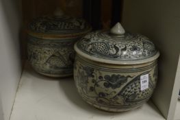 Two similar Oriental blue and white pottery bowls and covers.