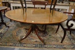 A mahogany oval tilt-top breakfast table.