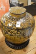 A Korean pottery jar and cover on hardwood stand.