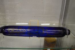 A blue glass commemorative rolling pin.