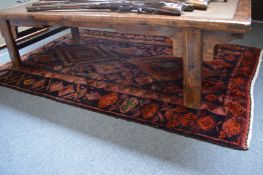 A Persian style rug, dark red ground with stylised decoration 218cm x 136cm.