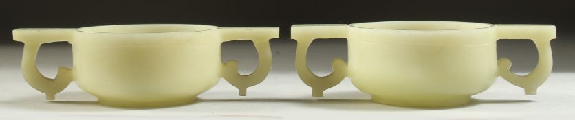 A PAIR OF CHINESE CARVED JADE TWIN HANDLE CUPS, 12cm wide (handle to handle).