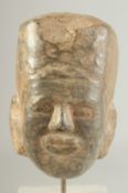 AN EARLY CARVED STONE HEAD, 11cm high.